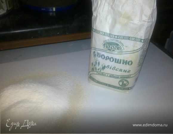 Просеять на рабочую поверхность овсяную муку и пшеничную муку.Сделать в горке углубление.