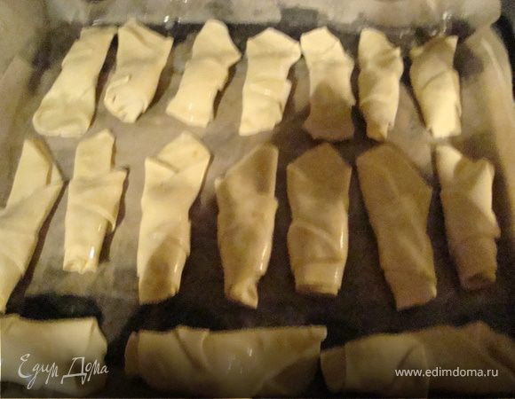 На широкую часть треугольника выкладываем наш шоколад где -то 1 чайную ложку.Заворачиваем к тонкому краю,концы хорошо защипляем.Получается форма лепесточка.
Выкладываем на противень,смазываем взбитое, венчиком яйцом.Духовку разогреваем до 200 градусов,ставим 
лист на средний уровень и выпекаем 25 минут.