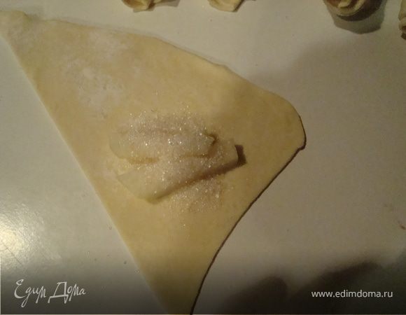 Если это ананас ,то колечки ананаса нарезаем тонкими полосками и так же на широкую часть треугольника выкладываем 2-3 полоски ананаса и немного присыпаем сахаром или сахарной пудрой.Заворачиваем .Концы хорошо защипляем.