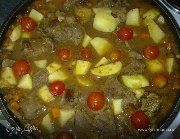 Добавляем мясо, солим и перчим, далее свежие и консервированные помидоры. Если консервированные помидоры у вас очень крупными кусками - перемелите их в блендере. 
Если сока от помидоров мало долейте в идеале бульона (но можно просто горячей воды). Пусть мясо чуть-чуть высовывается. И оставить  на среднем огне на час-два. Минут за пятнадцать до окончания готовки кидаем крупно порезанный картофель и помидорки черри и розовый перец Накрываем крышкой и доводим уже до готовности картофеля. 
