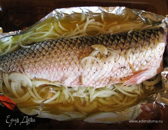 Лук порезать полукольцами, выложить вокруг рыбы. Края фольги приподнимаем, как бы сооружая форму. Смешиваем сок из одного апельсина, 100 мл вина и оливковое масло. Поливаем рыбу