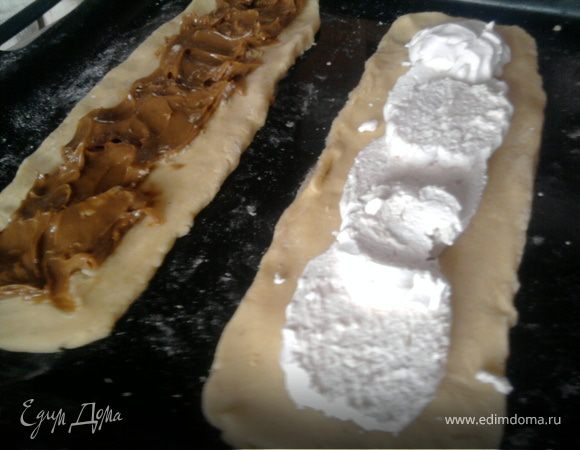 А можно разделить тесто на несколько частей (у меня на 6 - 3 побольше и 3 поменьше). Части побольше раскатать в полосы шириной 10 см и около 0,5 см толщиной. Выложить на середину этих полосок начинку - у меня это: вареная сгущенка; клубничный джем; зефир, покрытый сладкой сырковой массой с изюмом.