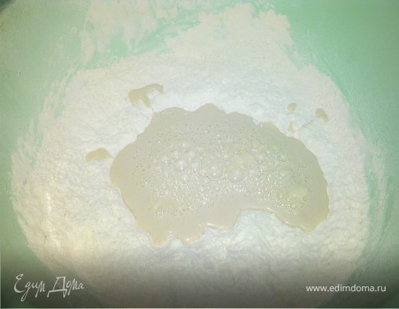 В центре горки сделать углубление .Подогреть молоко,раскрошить дрожжи,смешать с молоком,хорошо растворив и добавить к муке,слегка перемешав.Прикрыть миску и поставить в теплое место на 15 минут.
