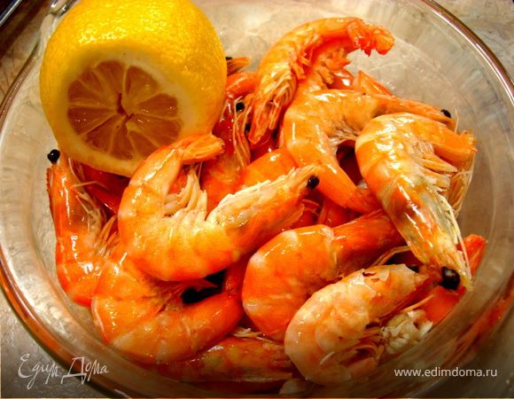 Если у вас креветка отварная и замороженная, то ее нужно просто разморозить, желательно в холодильнике, а потом сбрызнуть оливковым маслом. Если-же она сырая, то необходимо отварить в течении 2 минут в кипящей воде с добавлением оливкового масла. Затем креветки вынуть, дать стечь, охладить и почистить. Рыбу нарезать тонкими ломтиками. Лимон нарезать тонкими полукольцами.