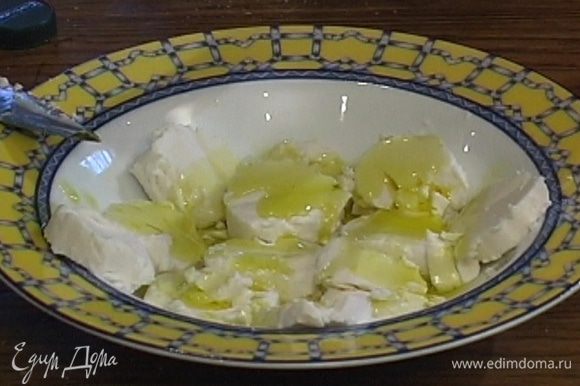 Козий сыр нарезать кружками, полить его 1 ст. ложкой оливкового масла.