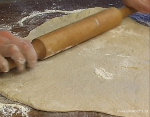 Разделить тесто на 2 части, раскатать одну часть в тонкий пласт и выложить на смазанный оливковым маслом противень.