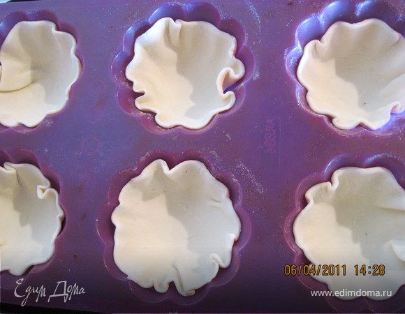 Тесто тонко раскатать, вырезать 6 кружков, уложить их в формочки 