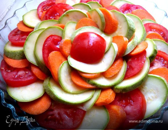 Разогреваем духовку до 180 гр.ц. Подготовим форму-обильно смазываем её раст.маслом и выкладываем на дно наш лук. Сверху присыпаем сухарями панировочными слегка. Далее по кругу выкладываем остальные овощи-у мея последовательность такова:кабачок,морвовь,помидор и так далее. Выкладываем всю форму.
