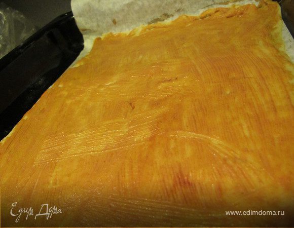 Смешать сметану с томат-пастой и тщательно смазать пласт.