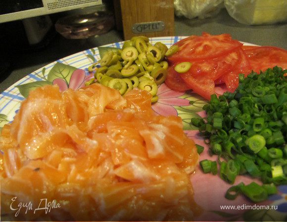 Помидор нарезать очень тоненькими колечками, семгу небольшими квадратиками, оливки кружками, лук мелко порубить.