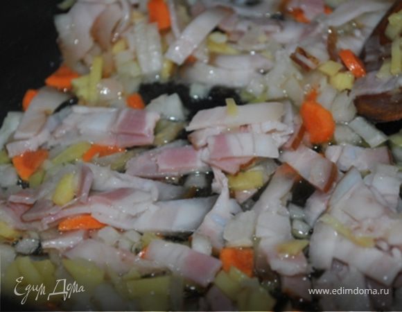 В кастрюле с толстым дном разогреть масло, положить лук, морковь, корень имбиря, грудинку и жарить на сильном огне 1 минуту.