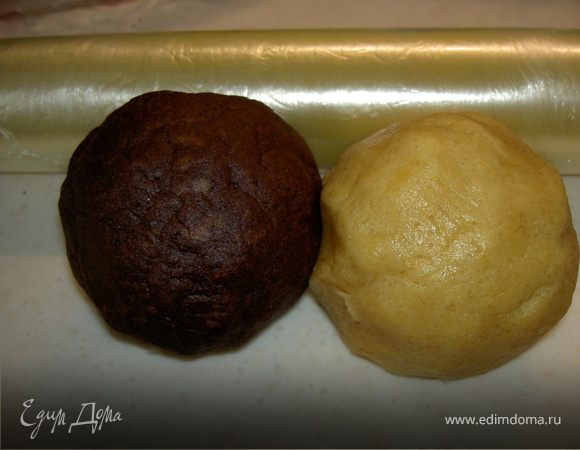 Замешиваем тесто из муки, сахара, ванильного сахара,желтков и масла. Разделим пополам и в одну половину добавим 2 ст. л. сливок, а в другую 3 ст.л. сливок и какао, сделаем два разноцветных шара, завернем их пленку и уберём на 1 час в холодильник.