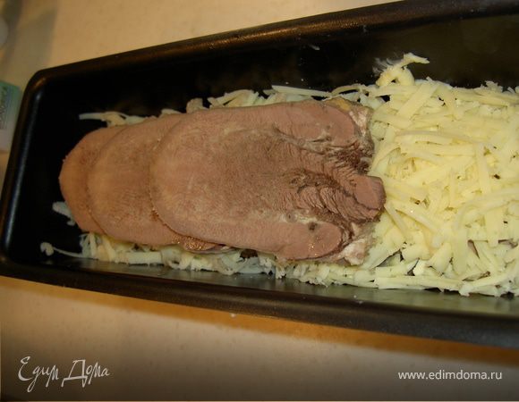 Укладываем в форму один ряд, довольно густо тертым сыром и поливаем растопленным маслом. Затем укладываем второй ряд языка., пересыпаем сыром, смешанным с сухарями и поливаем остатками масла.