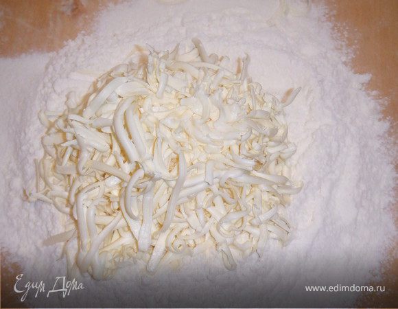 Муку просеиваем, делаем углубление и натереть на терку масло. Перетереть масло с мукой.