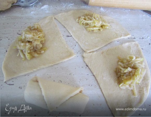 Раскатайте круглую лепешку, разрежьте ее на 4 сегмента, выложите на край начинку и аккуратно сверните, подгибая внутрь края.