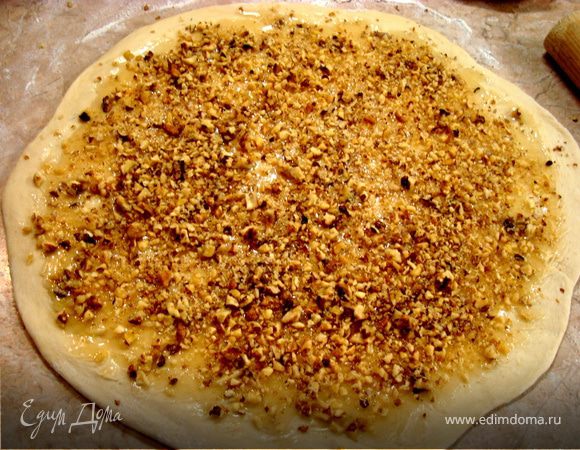 Получилось отличное дрожжевое сдобное тесто, из которого вы можете выпекать все, что душе угодно… Это могут булочки, пышки, пироги и т.д. Мы будем печь розы!!! Во-первых это необычно, а во-вторых жутко красиво!!! Итак.. тесто делим на две части. Каждую раскатываем толщиной около 7мм. Выливаем половину нашего меда (если он  вас густой, то растопите его предварительно в микроволновке или на водяной бане и остудите) на тесто и густо посыпаем орехами…