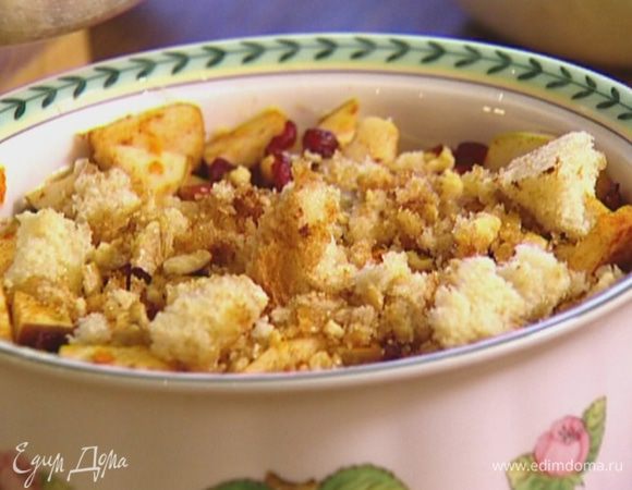 Покрошить оставшийся кусок батона, влить оставшееся растопленное масло, добавить сахар, орехи и корицу, перемешать и выложить сверху на яблоки.