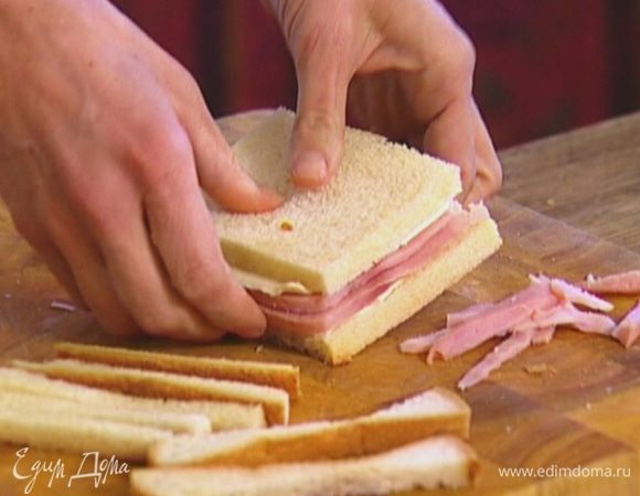 С хлеба срезать корки, на один кусок выложить ломтик сыра, затем 2 ломтика ветчины и снова сыр. Накрыть вторым куском хлеба, срезать лишние края.