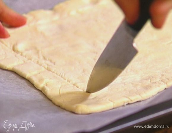 Тесто немного растянуть руками, выложить в противень. Отступая от края теста на 1,5 см, сделать кончиком ножа надрезы, не прорезая насквозь, чтобы получились бортики.