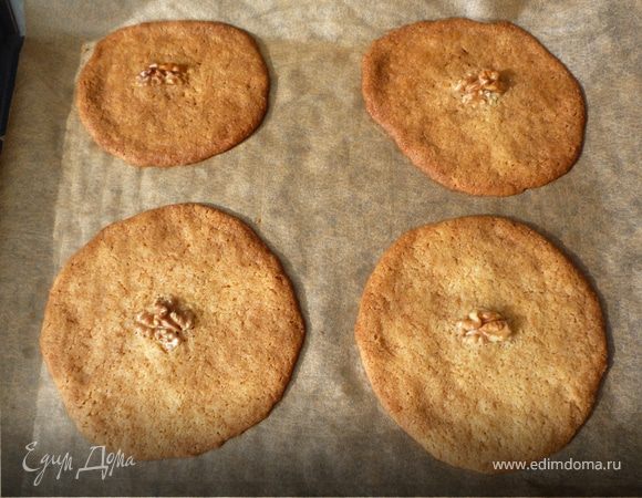 Разогреваем духовку до 190°C. Тесто в виде ровных лепешек распределяем на противне, покрытом бумагой для запекания. Медальки должны располагаться на большом
расстоянии друг от  друга, т.к. в процессе готовки они немного расплываются. На 1-ом противне не больше 6 штук. В центр каждой медали кладем грецкий орех.
Выпекаем 12 минут. Охлаждаем на решетке или на бумажных полотенцах. 