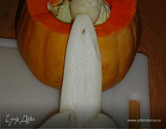 Оставшуюся половину дайкона разрезаем еще раз вдоль, более длинную часть прикрепляем к тыкве, меньшую часть разрезаем поперек и крепим к нижней части дайкона. 