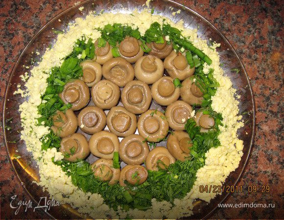 В центр блюда выложите шампиньоны шляпками вниз. Вокруг грибов выложите мелко нарезанную зелень и яичный желток.