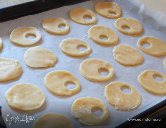 Духовка 165С. Деко застелить бумагой. Тесто раскатать, стаканом выдавить кружки, в половине из них сделать еще меньшее отверстие (я взяла приспособление для чистки яблок-серединки). Выпекать печенье минут 13 (не слишком долго). Остудить. На целые кружки положить чайную ложку джема, накрыть кружком с отверстием.