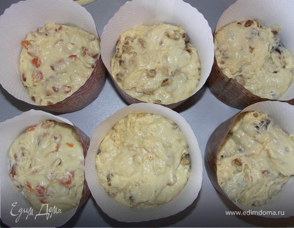 Вмесить в тесто фруктово-ореховые смеси руками.Разложить по формочкам так,что бы тесто заполняло их не более чем на половину и оставить под салфеткой подниматься в тёплом месте.