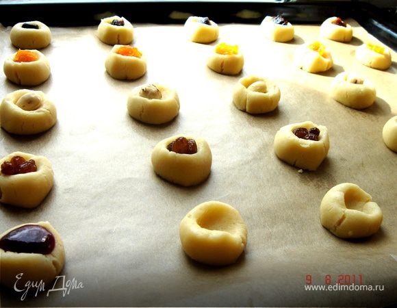 Разделить тесто на 2-3 части,каждую скатать в жгут d 1,5-2 см и нарезать на кусочки,шириной 1,5-2 см.Выложить на противень,застеленный бумагой для выпечки.Каждое печеньице вдавить по середине большим пальцем.В образовавшуюся выемку положить начинку.Вариантов начинки множество:джем,повидло,подсушенная  ореховая крошка с мёдом,сухофрукты и т.д.Поскольку печенье выпекается довольно долго,сухофрукты лучше предварительно хорошо вымочить.Выпекать при t 160*С до готовности(ок. 30 мин). 