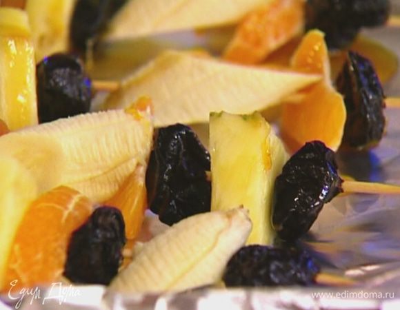 На каждую шпажку нанизать 1 курагу, кусочек ананаса, 1 чернослив, кружок банана, дольку мандарина и опять чернослив.