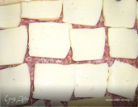 сыр нарежем тонкими ломтиками и выкладываем его на фарш равномерно