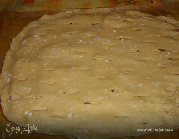 вторую часть теста раскатать также как и первую равную по размеру и тощине,сделать  надрезики мелкие ножом и накрыть сверху пирог, края защипить,сверху 