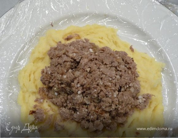 Сформируйте зразы. Очень удобно это делать с помощью пищевой пленки, смазанной маслом, так зразы будут идеально ровными, а руки — чистыми. К тому же, экономит время и нервы: столовую ложку пюре с горкой распределите по кругу, в центр положите столовую ложку фарша, разровняйте. Поднимите края пленки, соединяя края картофельного «пирожка», защипните и придайте форму.