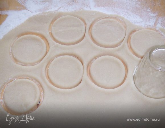 Раскатываем тесто, и стограммовой рюмкой делаем углубление, в форме колечек. 