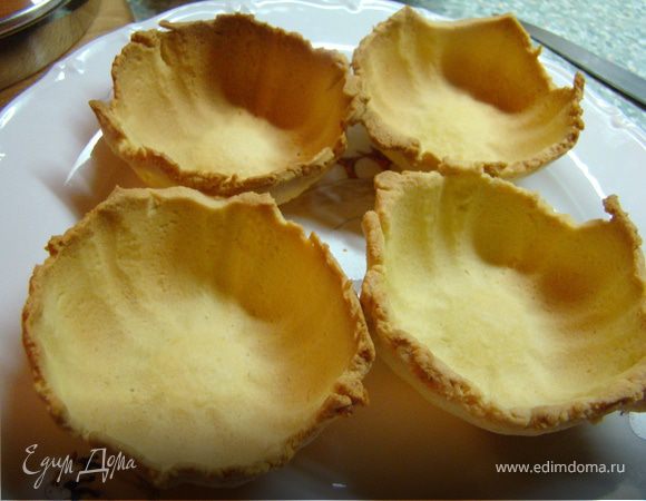 На самом деле, у меня просто осталось тесто и сливки после  приготовления орехового пирога (http://www.edimdoma.ru/recipes/18748). И мне не хотелось, чтобы это все добро пропадало. 

И так, я хотела сделать милые корзиночки, но специальных формочек у меня нет. Поэтому, я взяла силиконовые порционные формы, перевернула их и покрыла раскатанным тестом, обрезав лишние края. 
Выпекала до готовности.
