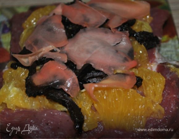 На кусок мяса положить апельсины, чернослив, имбирь, апельсиновую цедру.