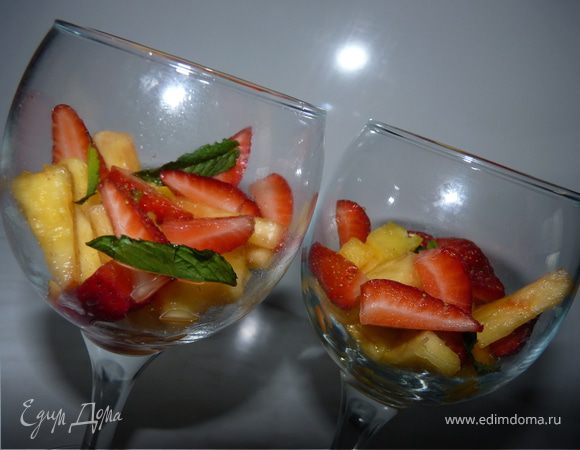 Ананас очистить, порезать на кусочки, клубнику также порезать. Выложить в креманки или бокалы, полить ликёром, украсить листиками мяты.
Для детей фрукты полить жидким мёдом.
