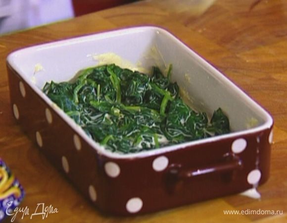 Небольшую форму для выпечки смазать сливочным маслом, выложить шпинат, равномерно распределить. 