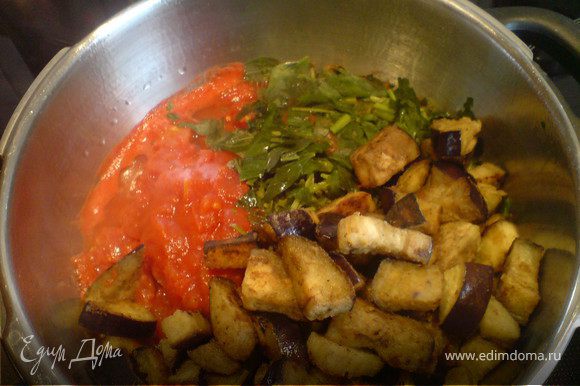 Влить в кастрюлю томатный соус, добавить обжаренные баклажаны, базилик, орегано и петрушку.