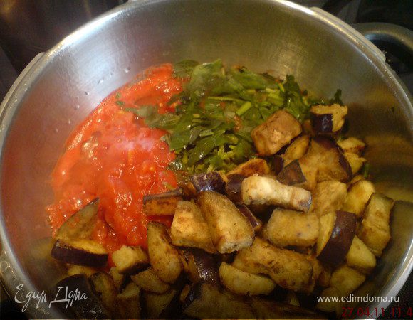 Влить в кастрюлю томатный соус, добавить обжаренные баклажаны, базилик, орегано и петрушку.