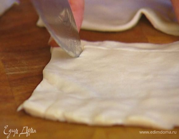 Тесто разморозить, слегка раскатать и разрезать на четыре части. В каждом квадрате, отступая на 1 см от краев, ножом прочертить квадрат меньшей площади, не прорезая тесто до конца, чтобы получились бортики. 