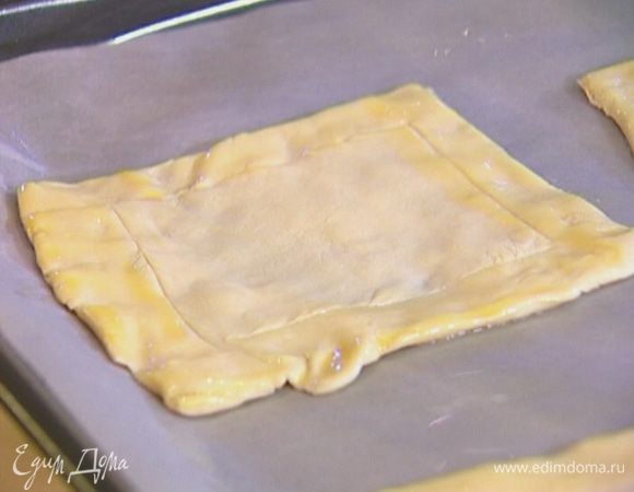Противень выстелить бумагой для выпечки, смазать ее оливковым маслом и выложить квадратики теста.