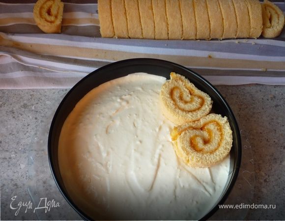  Разрезаем рулет на 12 одинаковых кусочков (у меня было использовано 9, но лучше не рисковать, зависит от того насколько широкий рулет). Выкдадываем эти рулетики поверх сливочного крема. 
Ставим в холодильник на 2 часа (я оставила на ночь, т.к. торт нужен был с утра).