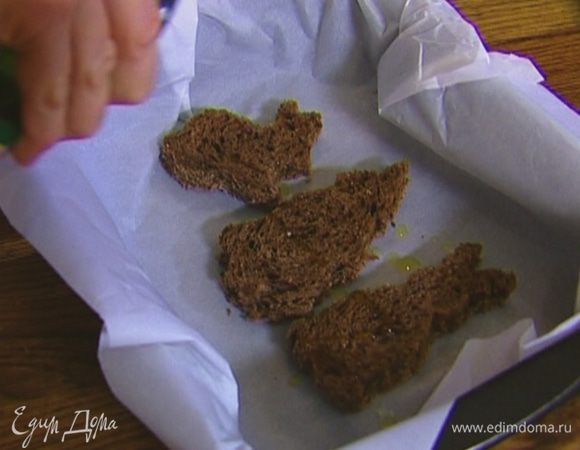 Противень застелить бумагой для выпечки, выложить вырезанные из хлеба кусочки мякиша, сбрызнуть оставшимся оливковым маслом, присыпать тертым сыром и отправить под гриль на несколько минут, чтобы сыр расплавился.