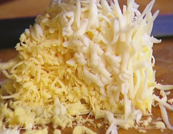 Оба сорта сыра натереть на крупной терке и выложить в форму с тестом. 