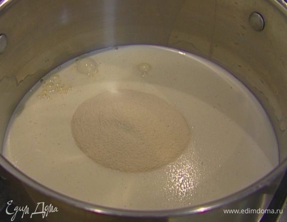 Манную крупу всыпать в кастрюлю, залить стаканом воды, влить молоко и перемешать.