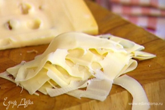 Сыр настрогать тонкими лепестками (лучше воспользоваться картофелечисткой или сырорезкой).