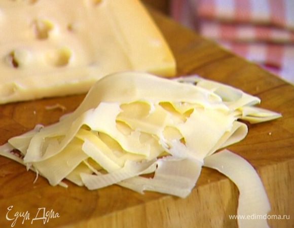 Сыр настрогать тонкими лепестками (лучше воспользоваться картофелечисткой или сырорезкой).