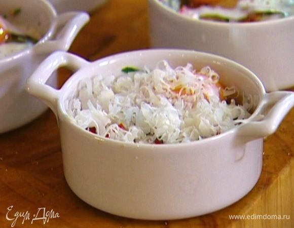 Разбить в каждую формочку по одному яйцу, добавить еще немного сливок, поперчить и присыпать сыром.