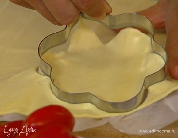 Пласт теста раскатать на пергаменте, вырезать формочками различные фигурки из теста. Оставшееся после вырезания фигурок тесто удалить.